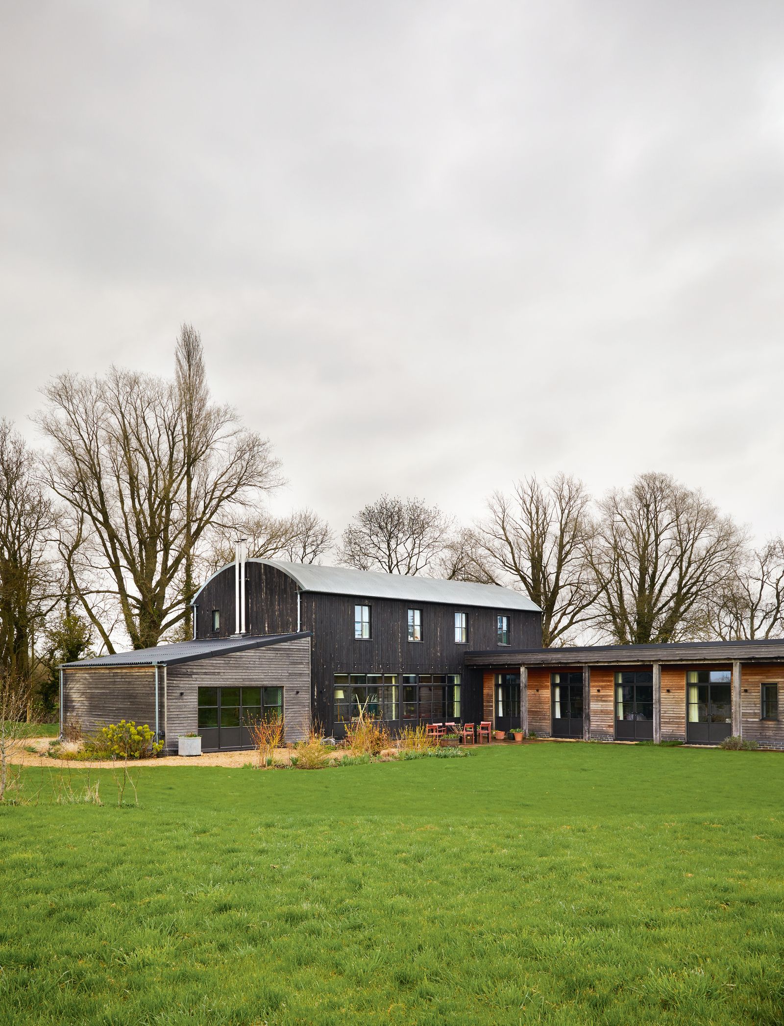 Charred ash cladding on the barn and darkframed windows from Met Therm are balanced by treated larch on the ‘room of...