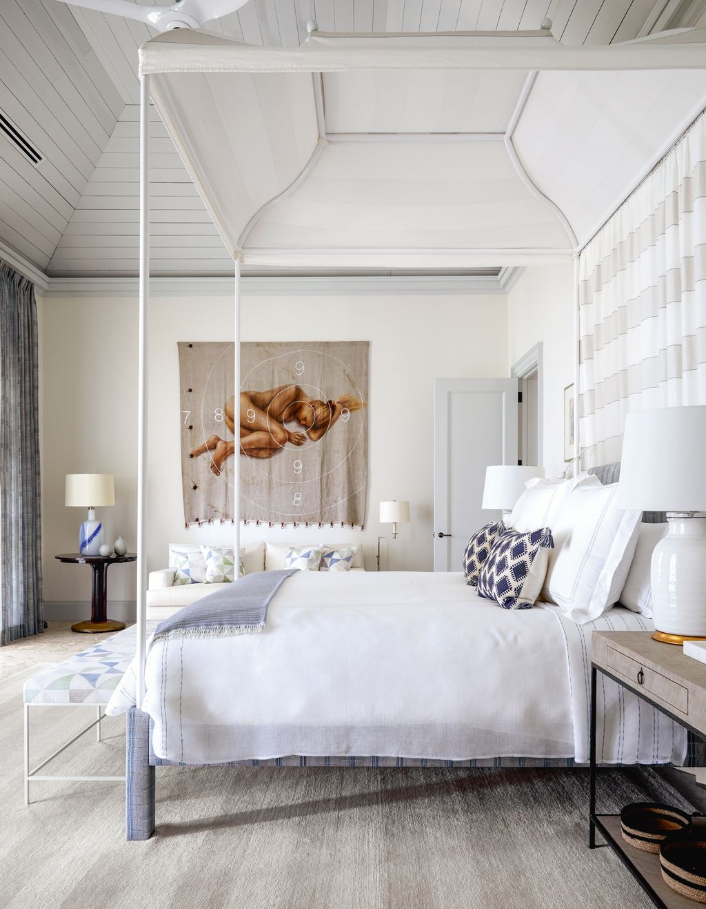 In the main bedroom an unusual artwork by Ivica Arandus is seen through the custommade metal baldachin bed frame based...