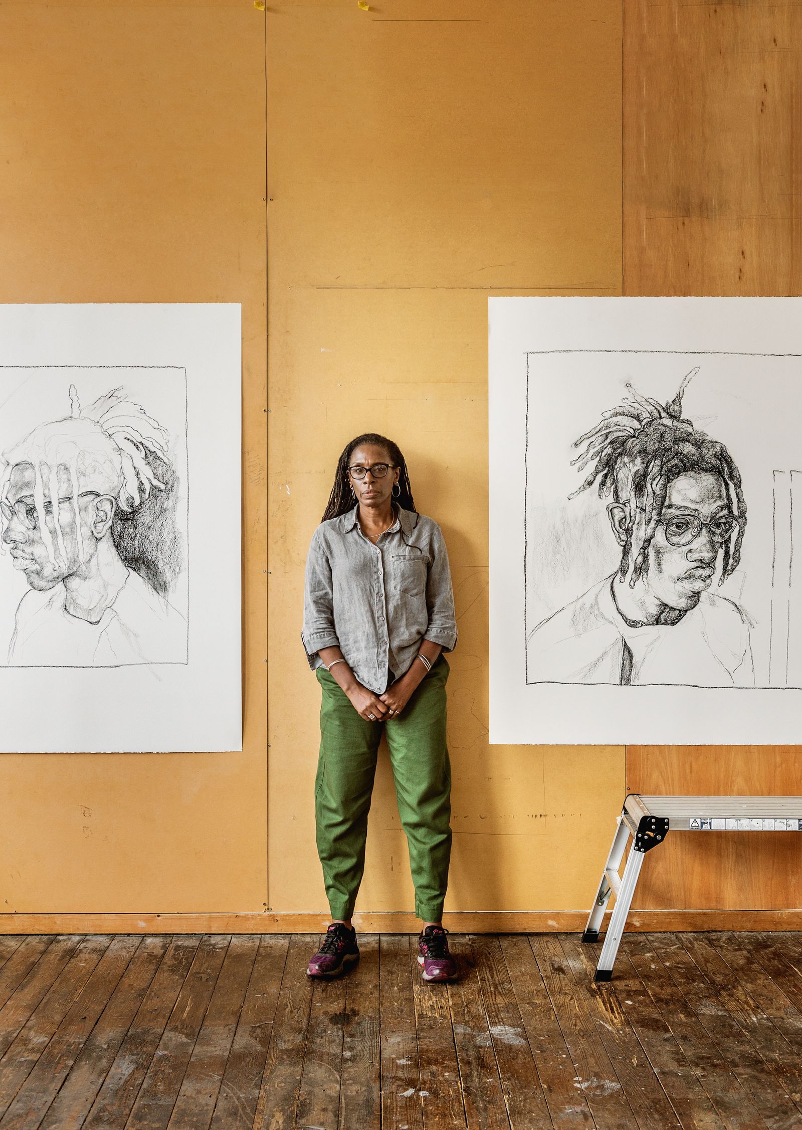 Barbara Walker in her Birmingham workspace with charcoal portraits of her grandson made in 2023.