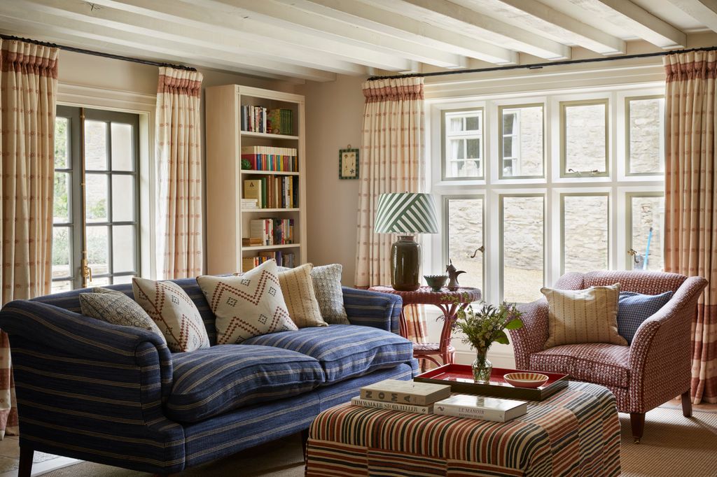 In the kitchen living space  a sofa in Kravet Couture's ‘Saddle Stripe contrasts with an armchair in Carolina Irving's...