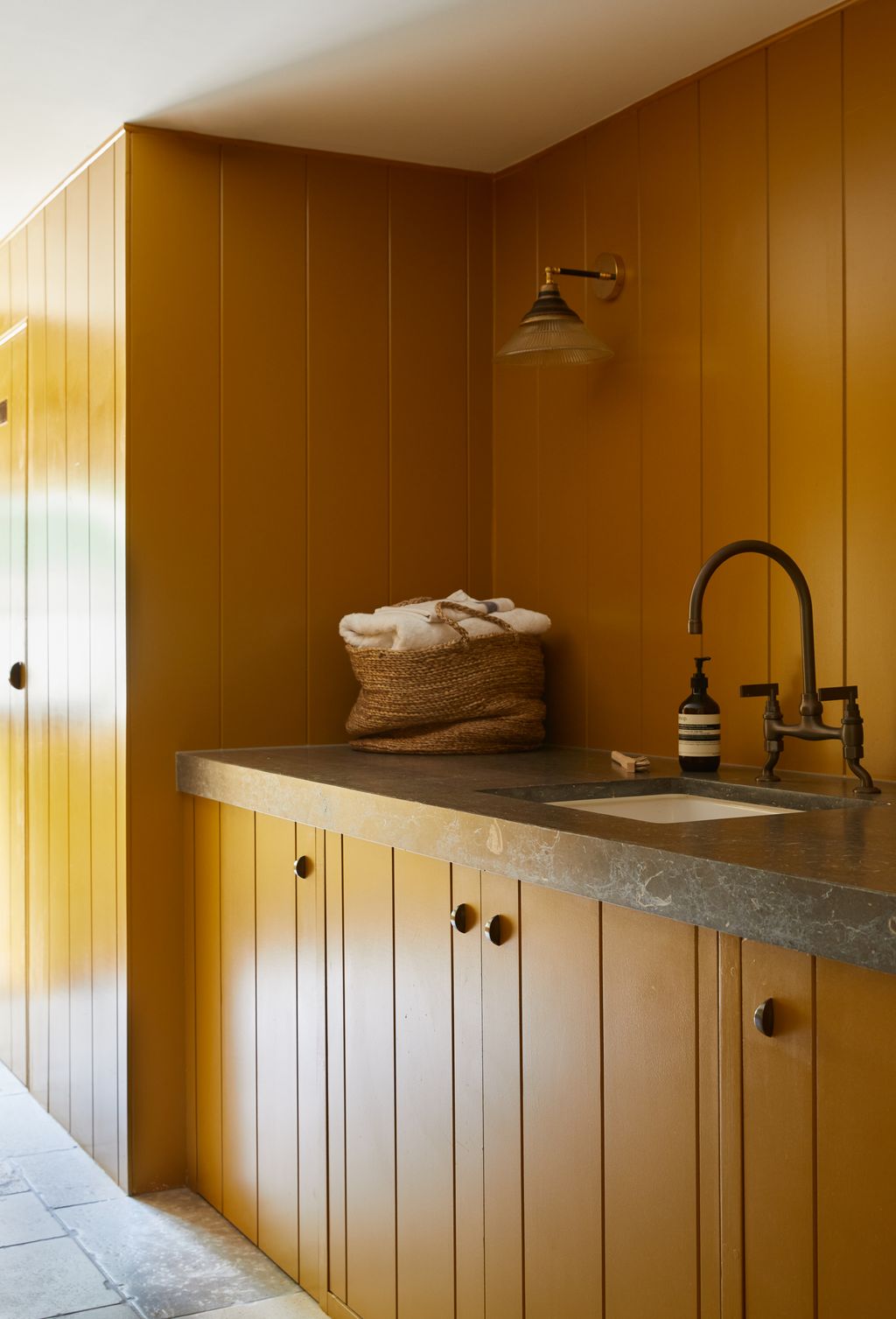 The countertop is made in Belgian stone with a mitred edge to give the illusion of a heavy solid stone top. A wall light...