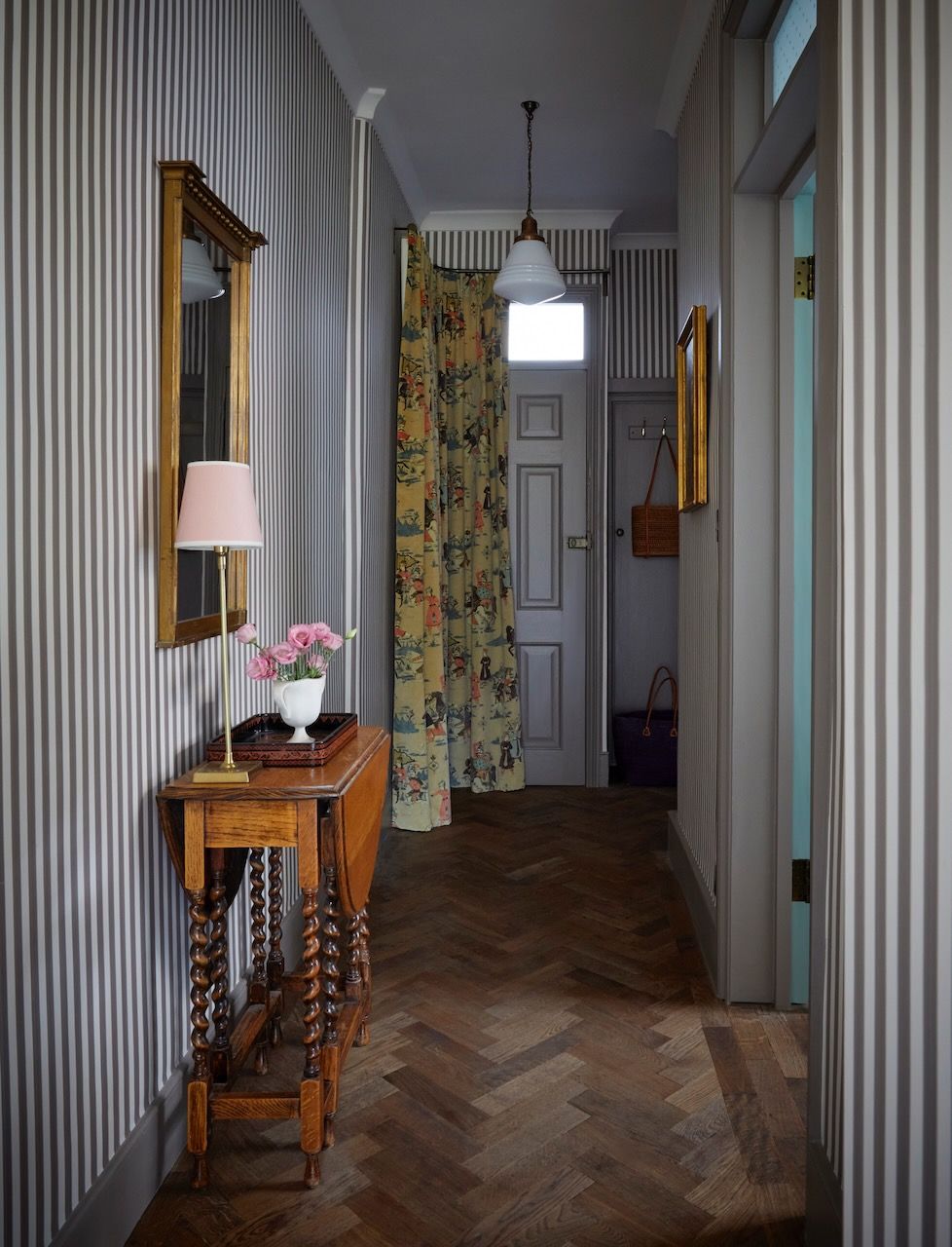 A clever use of stripes enlivens the narrow hallway of this London Victorian flat by Laura Stephens