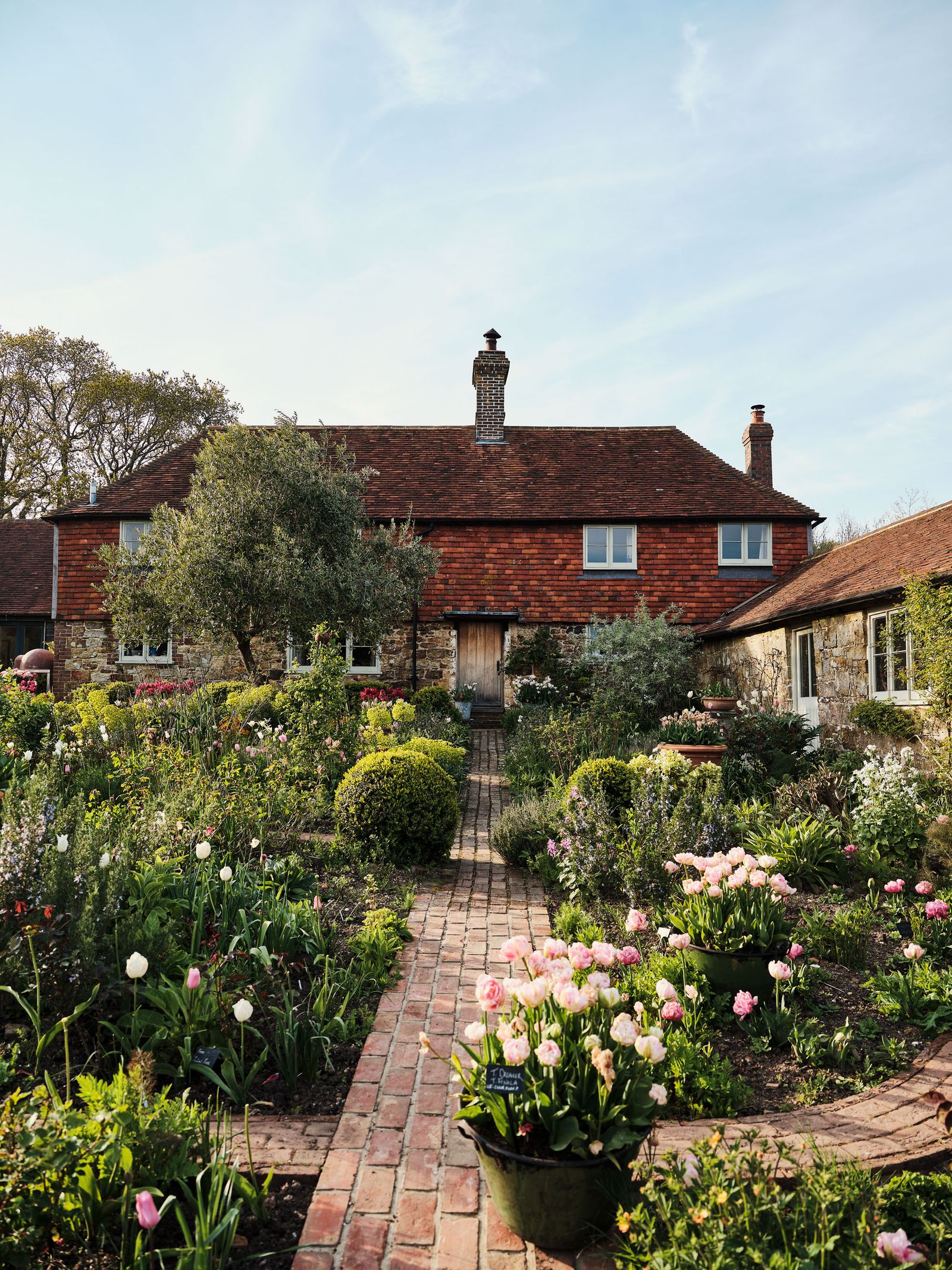 Image may contain Architecture Building Cottage House Housing Garden Nature Outdoors Jar Plant and Planter