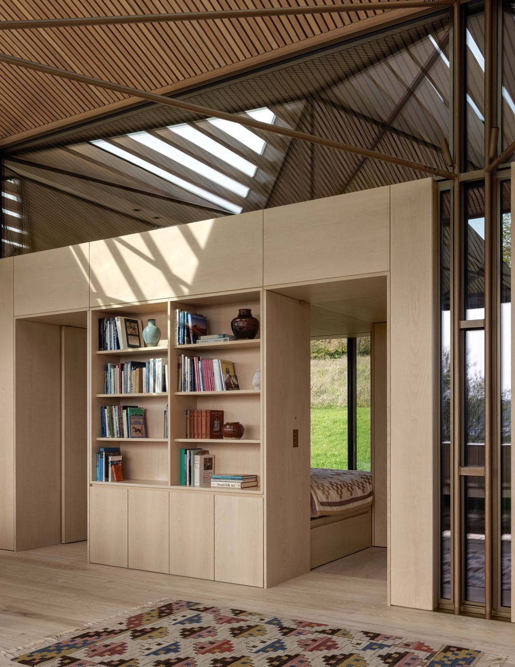 Image may contain Indoors Interior Design Furniture Home Decor Rug and Bookcase