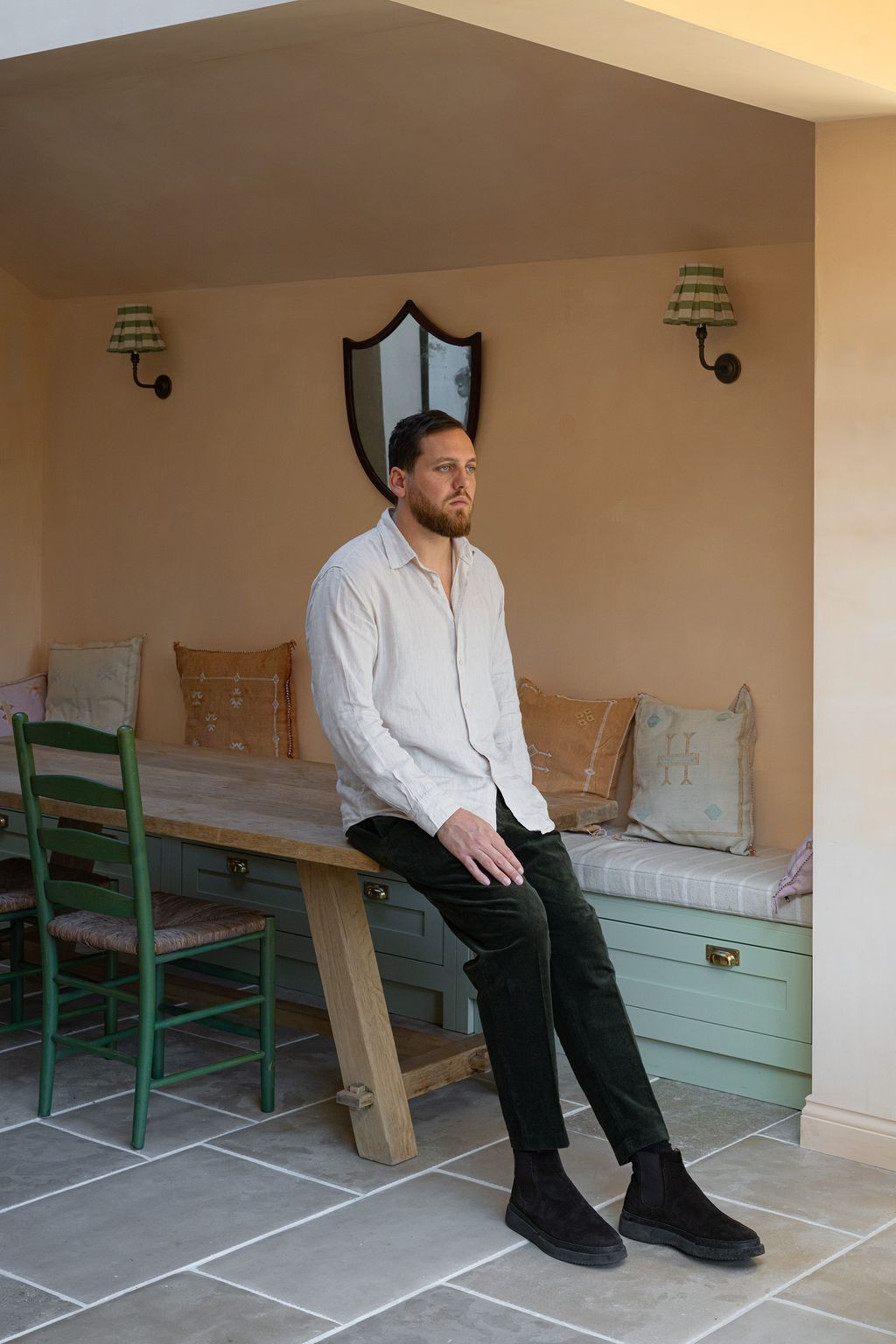 Image may contain Person Sitting Lamp Clothing Pants Adult Chair Furniture Footwear and Shoe