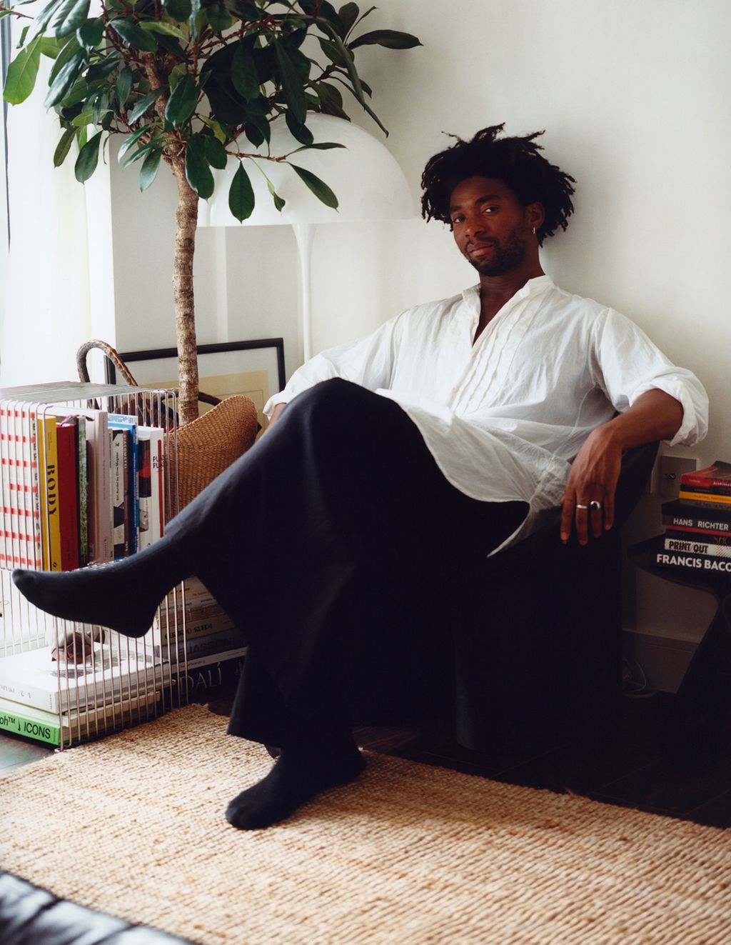 Image may contain Person Sitting Adult Home Decor Rug Clothing Footwear Shoe and Plant