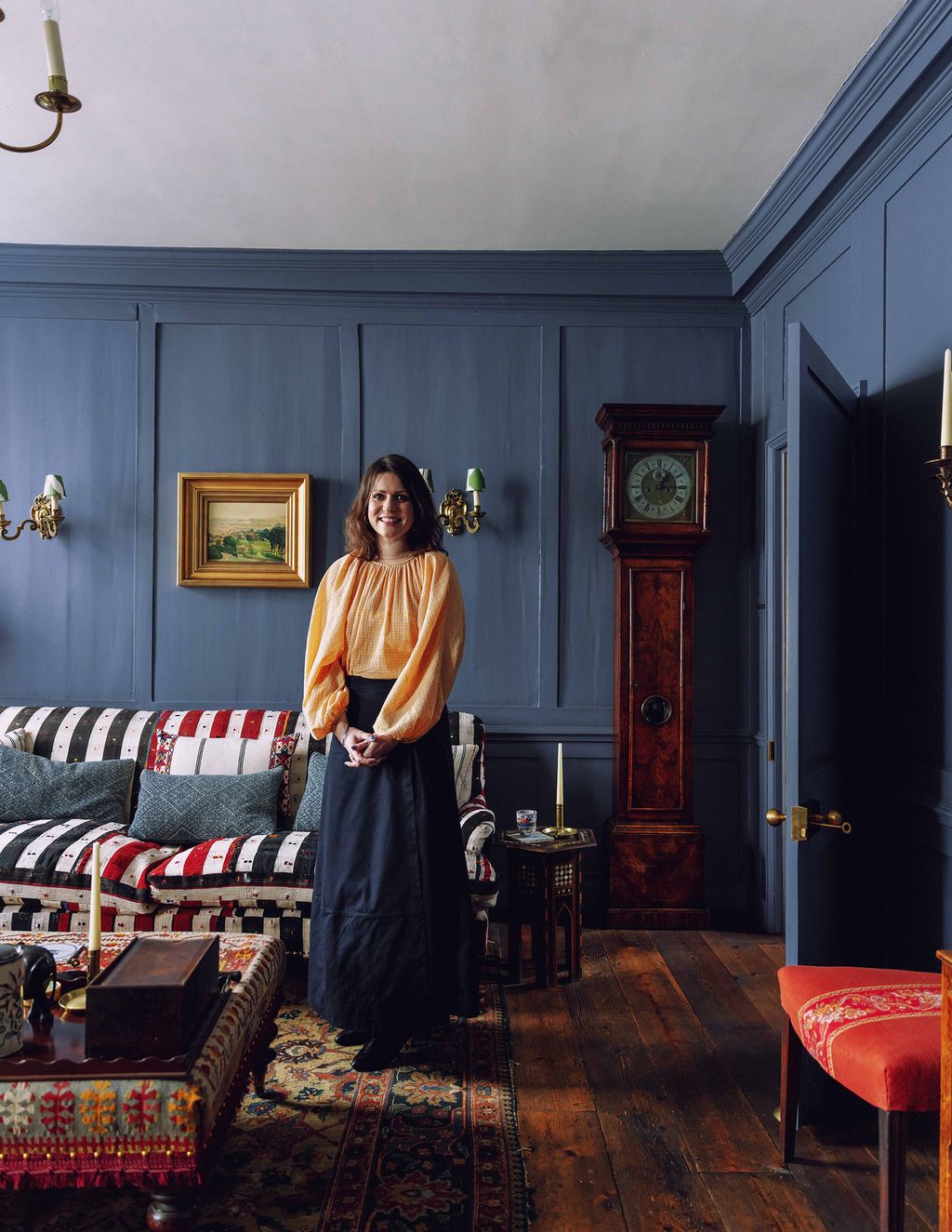 Image may contain Adult Person Art Painting Lamp Chair Furniture Cup Desk Table Couch Sitting and Candle