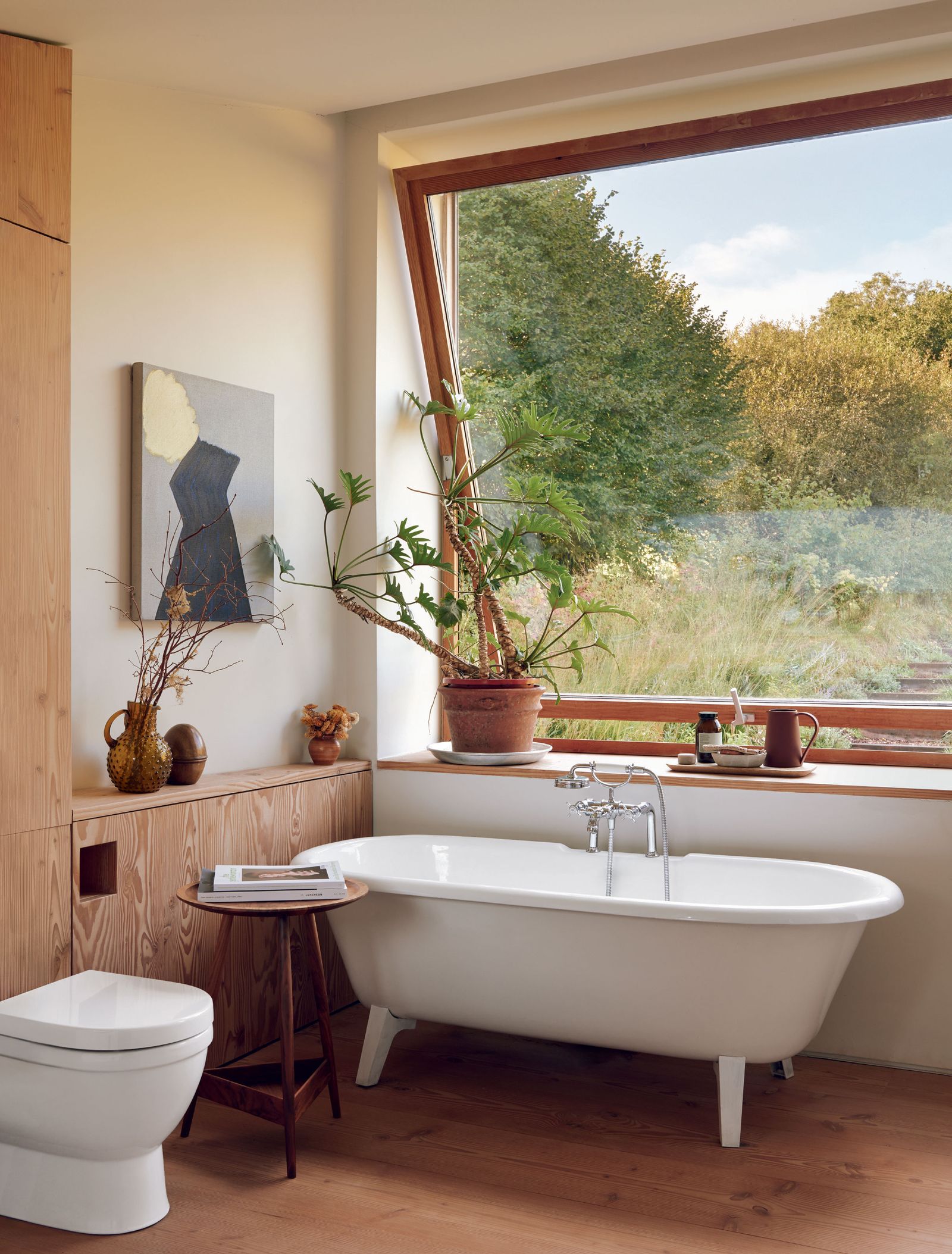 Image may contain Bathing Plant Bathtub Person Tub Indoors Interior Design Bathroom Room Toilet Cup and Desk