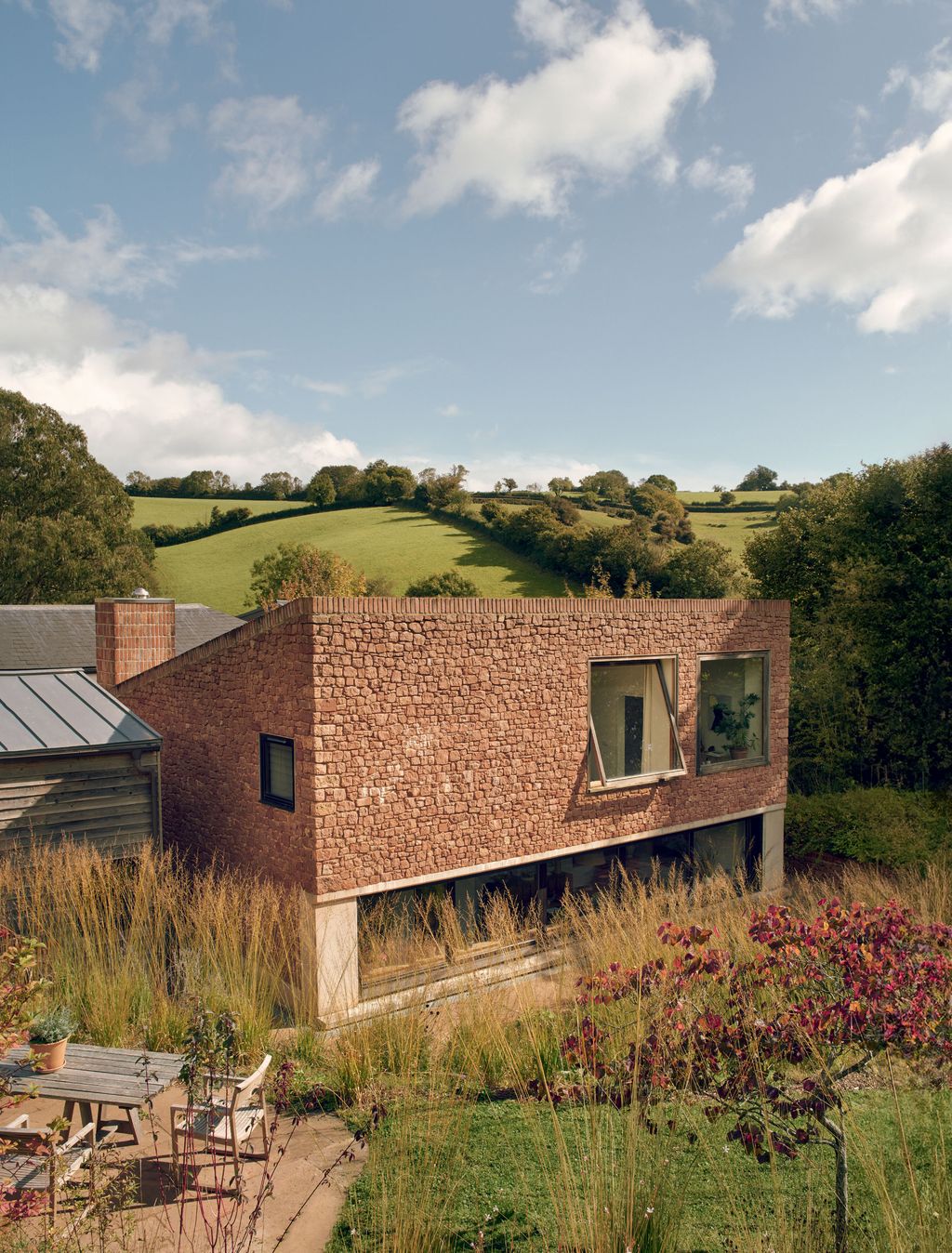Image may contain Architecture Building Cottage House Housing Outdoors Shelter Grass Plant Chair and Furniture