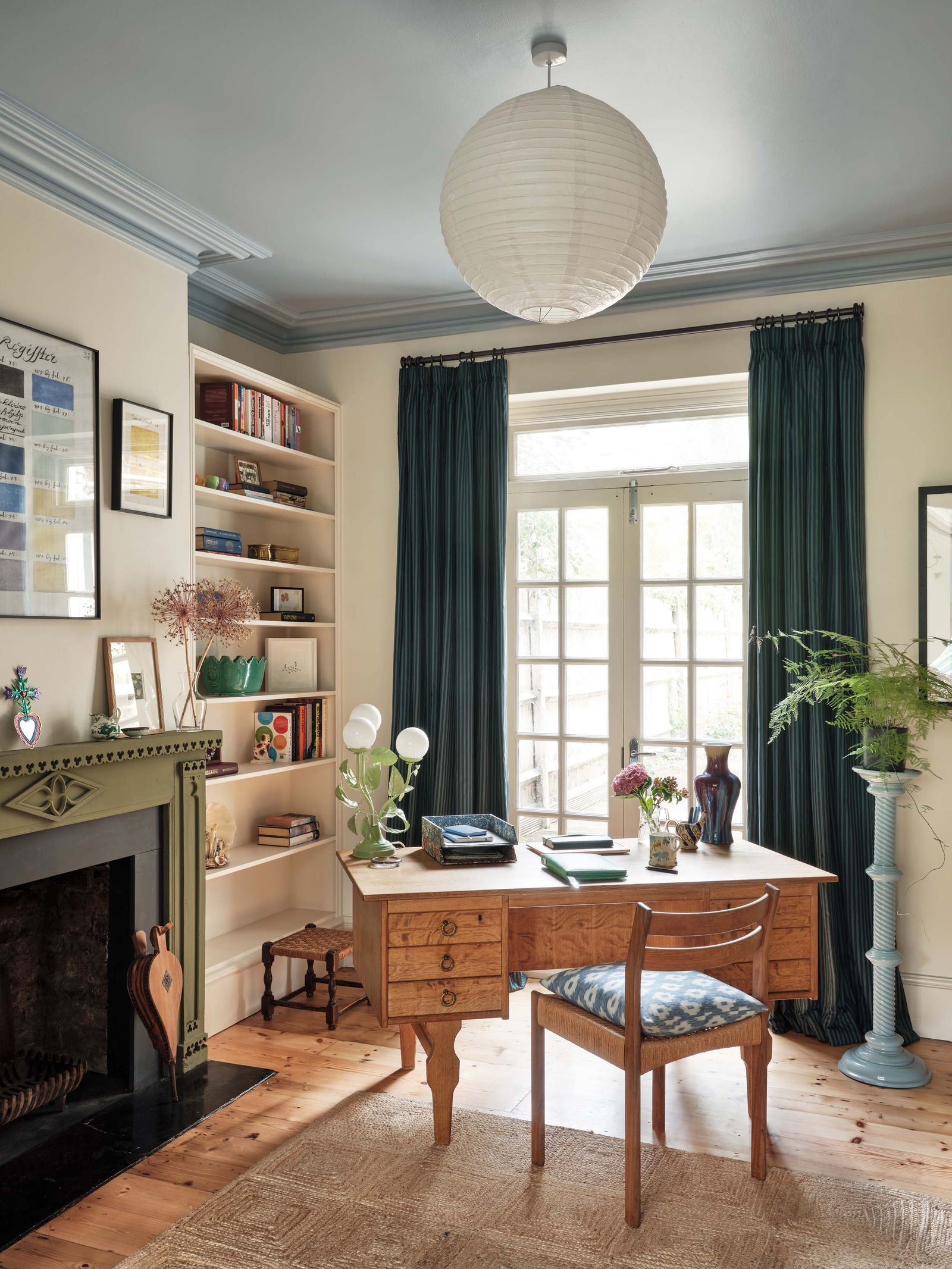 Image may contain Chair Furniture Plant Lamp Desk Table Home Decor Indoors Interior Design Rug Art and Painting