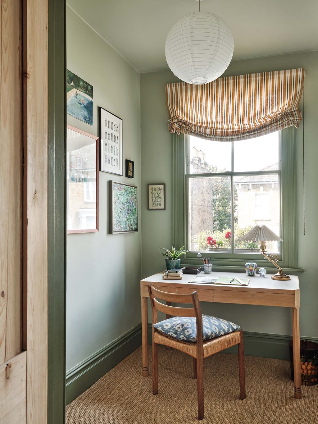 Image may contain Desk Furniture Table Chair Plant Corner Lamp Cup Book Publication Window Art and Painting