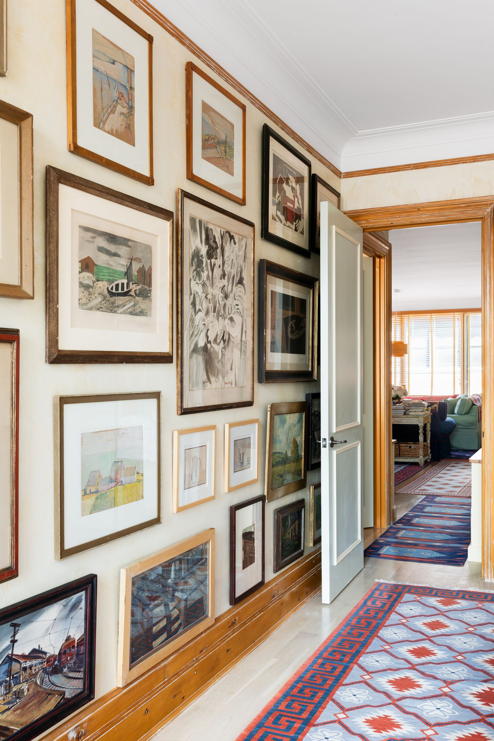 Image may contain Home Decor Rug Art Painting Floor Couch Furniture Lamp Art Gallery and Person