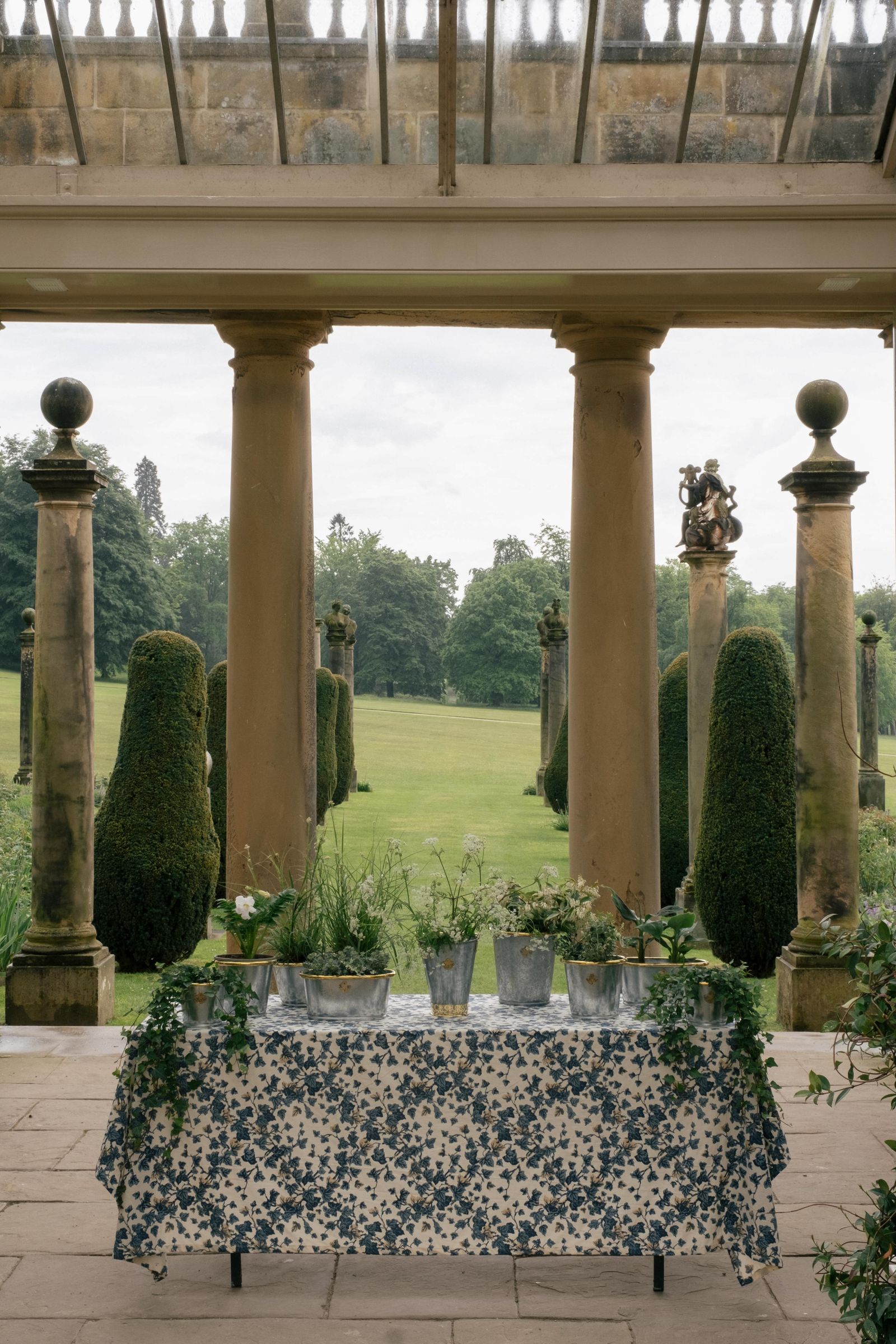 Image may contain Grass Plant Potted Plant Architecture Building House Housing Porch Jar Planter Pottery and Vase