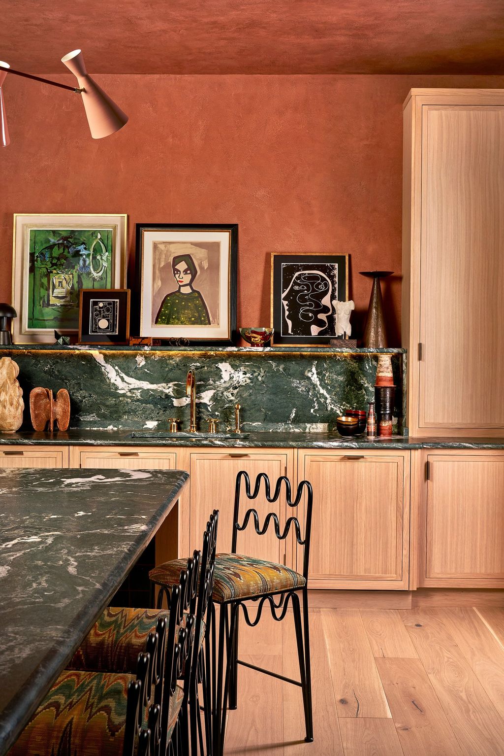 Image may contain Indoors Interior Design Art Painting Wood Lamp Chair Furniture Adult Person Floor and Kitchen