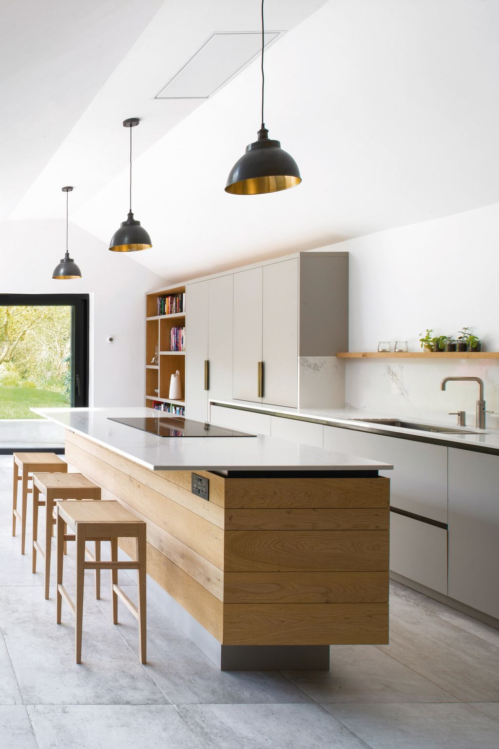 Image may contain Indoors Interior Design Kitchen Kitchen Island Cooktop Sink Sink Faucet Furniture Plant and Lamp