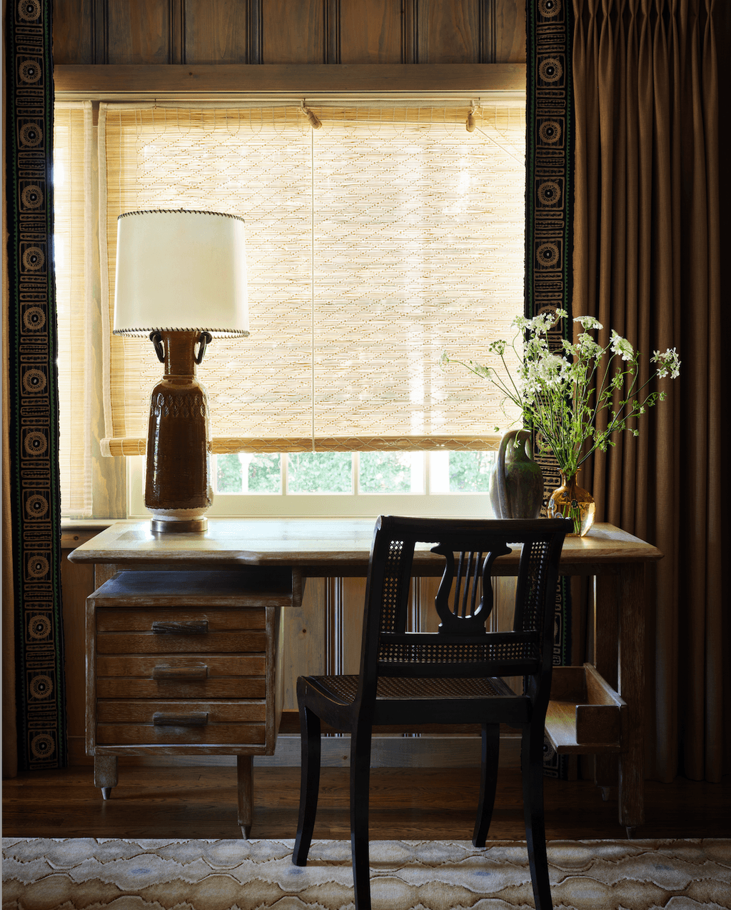 Image may contain Indoors Interior Design Lamp Flower Flower Arrangement Plant Furniture Table Table Lamp and Chair