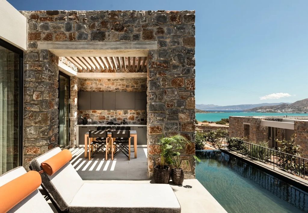 Image may contain Architecture Balcony Building Plant Chair Furniture House Housing Villa Pool and Water