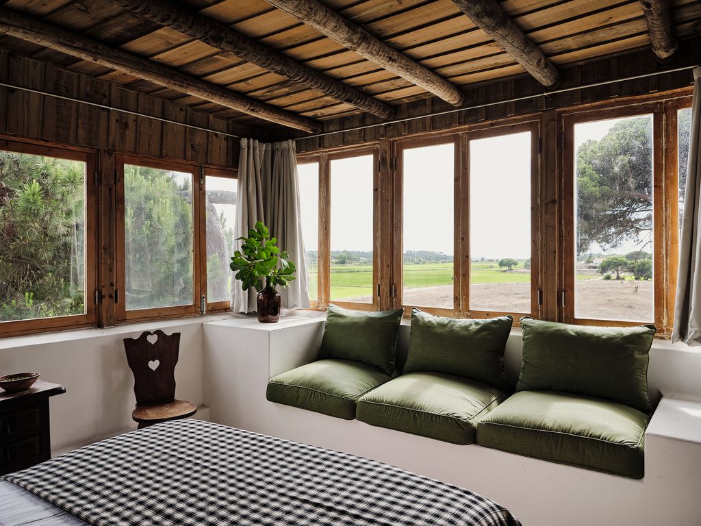 Image may contain Window Plant Chair Furniture Bed Indoors Interior Design Bay Window and Couch