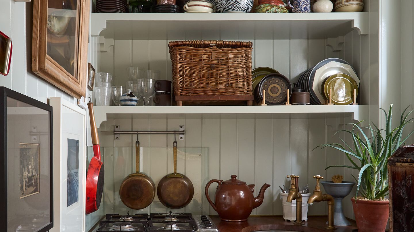 Image may contain: Indoors, Interior Design, Plant, Lamp, Chandelier, Sink, Cooktop, Kitchen, Shelf, Cup, Art, and Painting