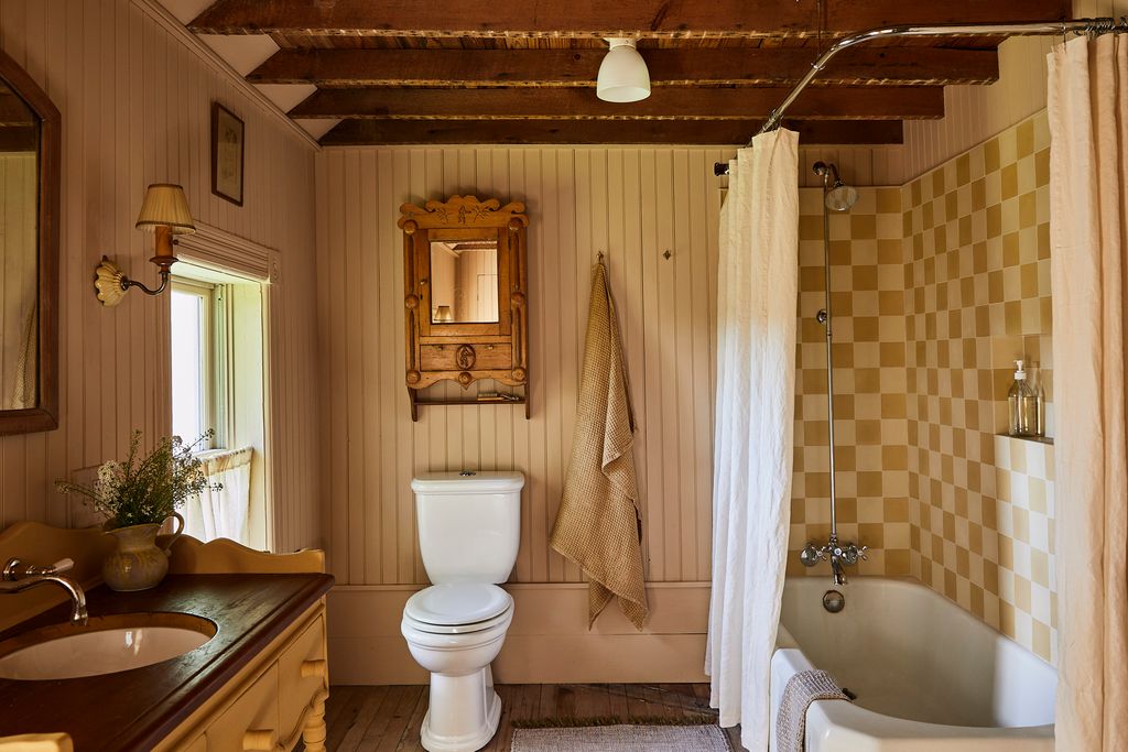 Image may contain Indoors Interior Design Lamp Sink Bathing Bathtub Person Tub Bathroom Room and Toilet