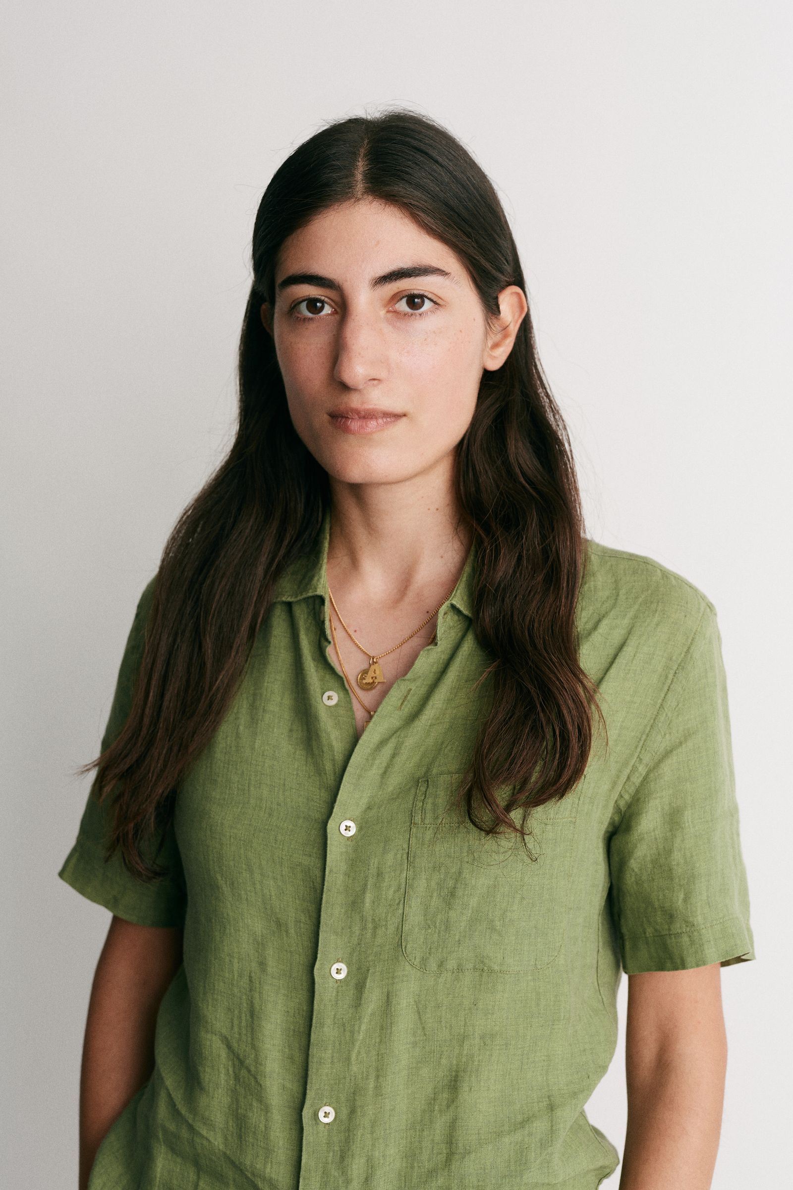 Image may contain Blouse Clothing Sleeve Accessories Jewelry Necklace Adult Person Head Face and Photography