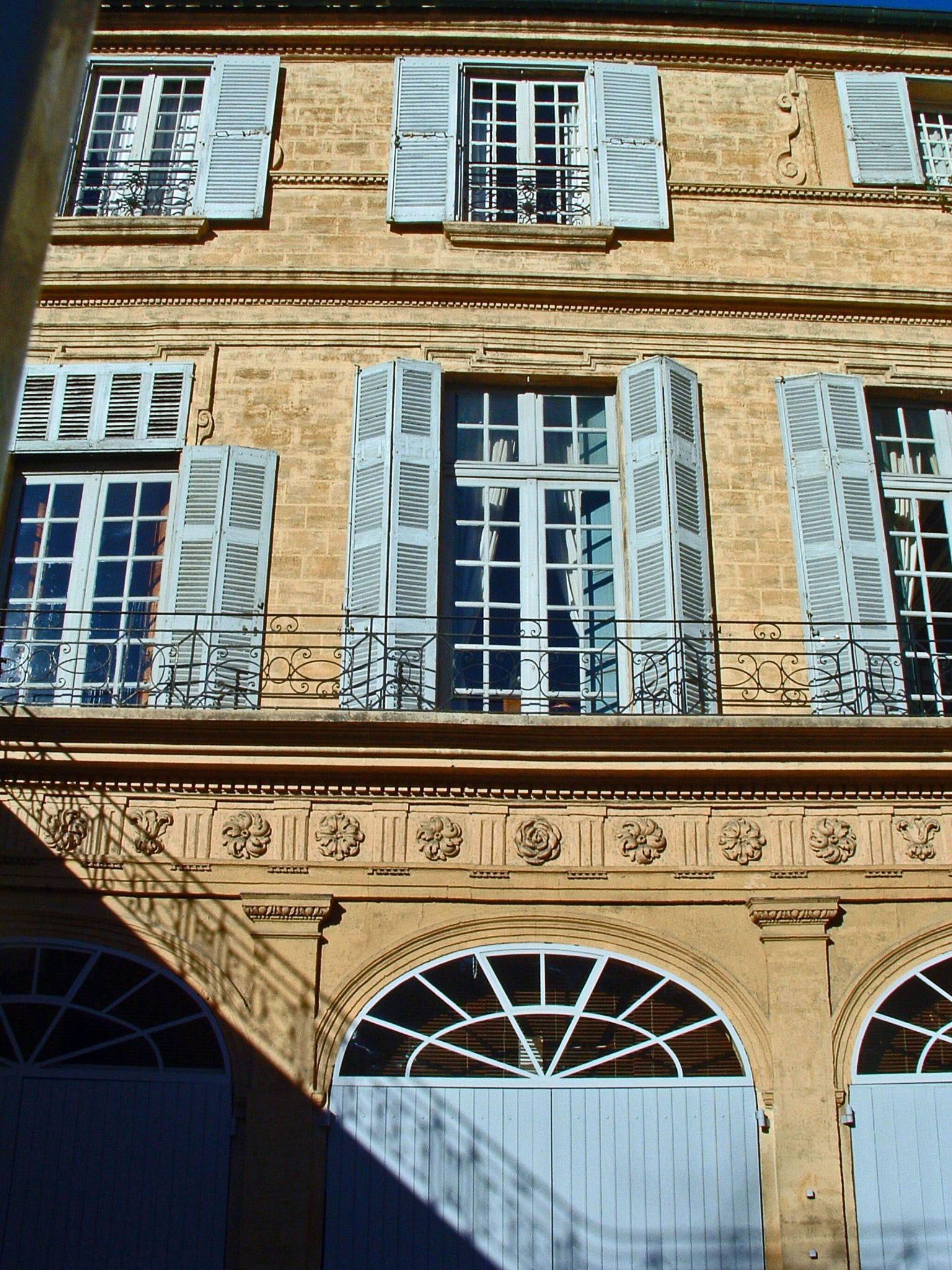 Alain Delon Aix en Provence Hôtel de Boisgelin façade en pierre jaune et volets provençaux bleu