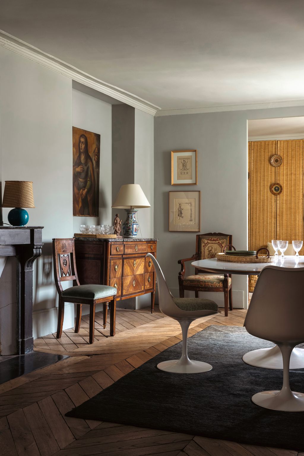 Image may contain Lamp Indoors Interior Design Home Decor Chair Furniture Rug Art Painting Table Person and Floor