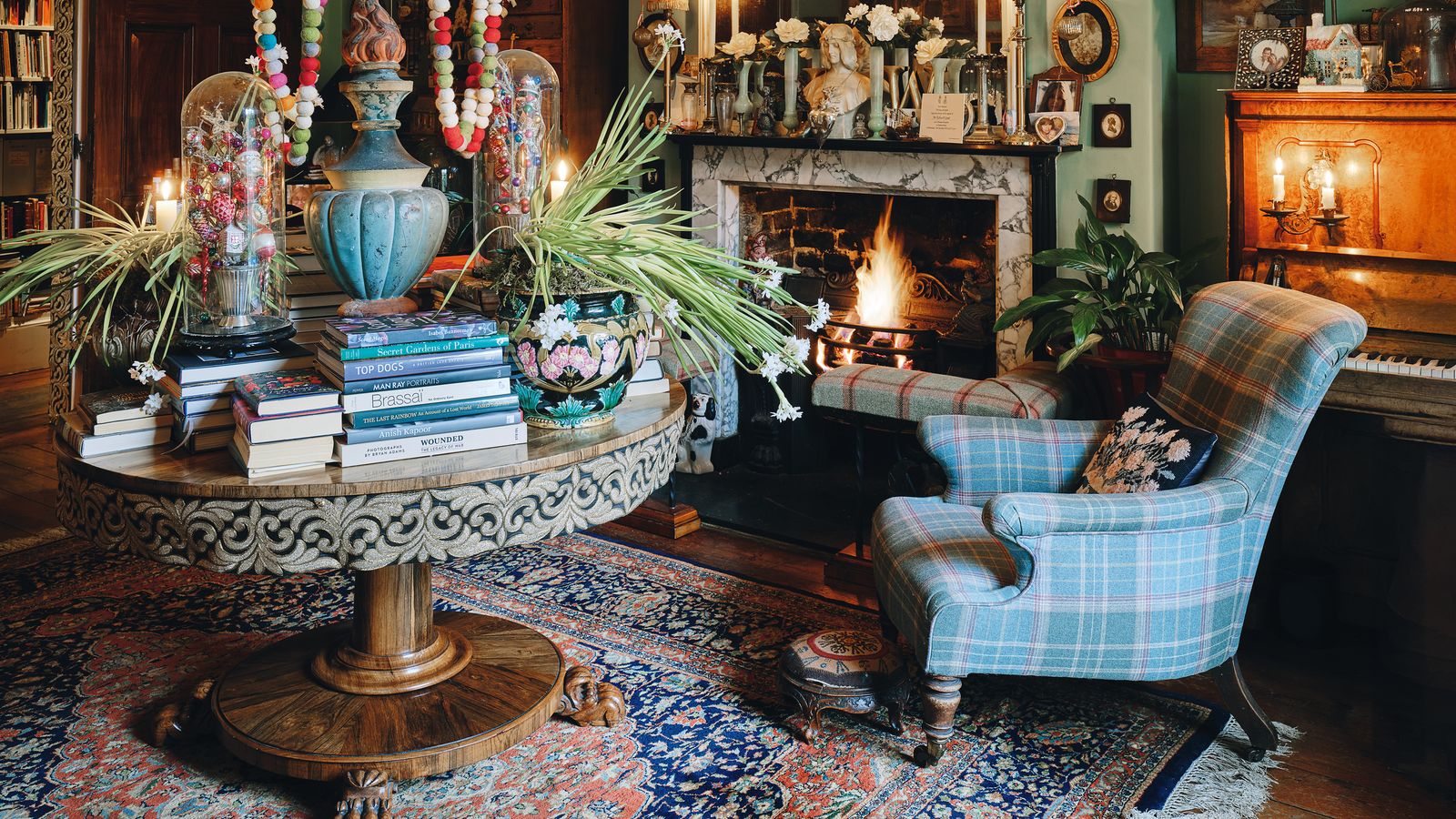 Image may contain: Home Decor, Plant, Rug, Art, Painting, Desk, Furniture, Table, Lamp, Chair, Chandelier, Clothing, and Hat