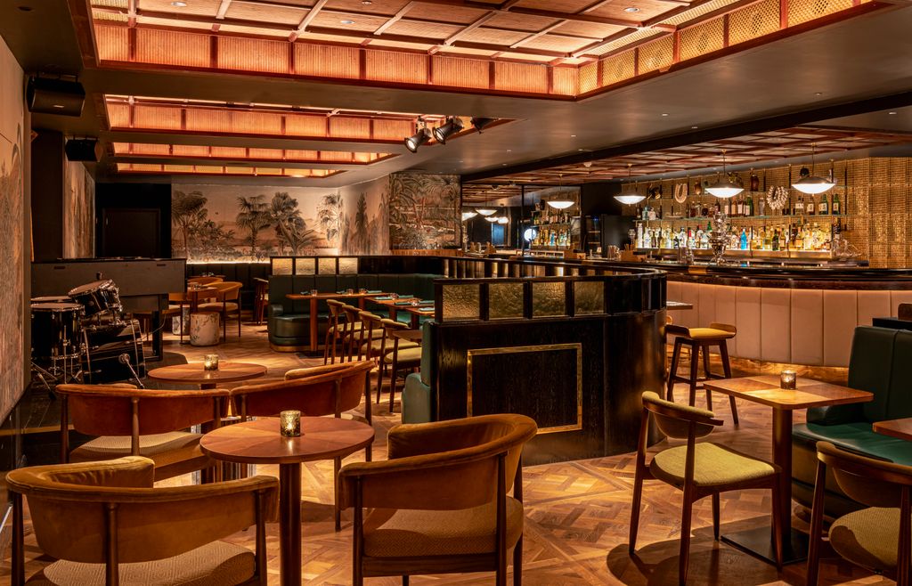 Image may contain Bar Chair Furniture Cup Lamp Desk Table Electronics and Speaker