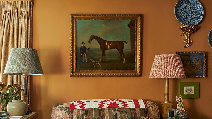 Image may contain: Lamp, Art, Painting, Table Lamp, Cushion, Home Decor, Plant, Desk, Furniture, Table, Person, and Indoors