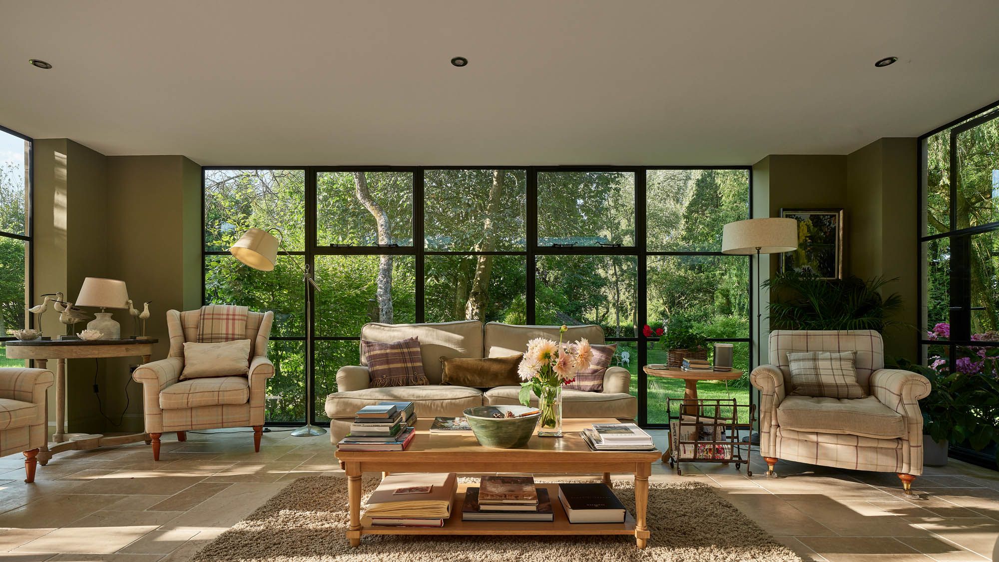 Image may contain: Home Decor, Coffee Table, Furniture, Table, Rug, Desk, Couch, Lamp, Chair, Book, and Publication