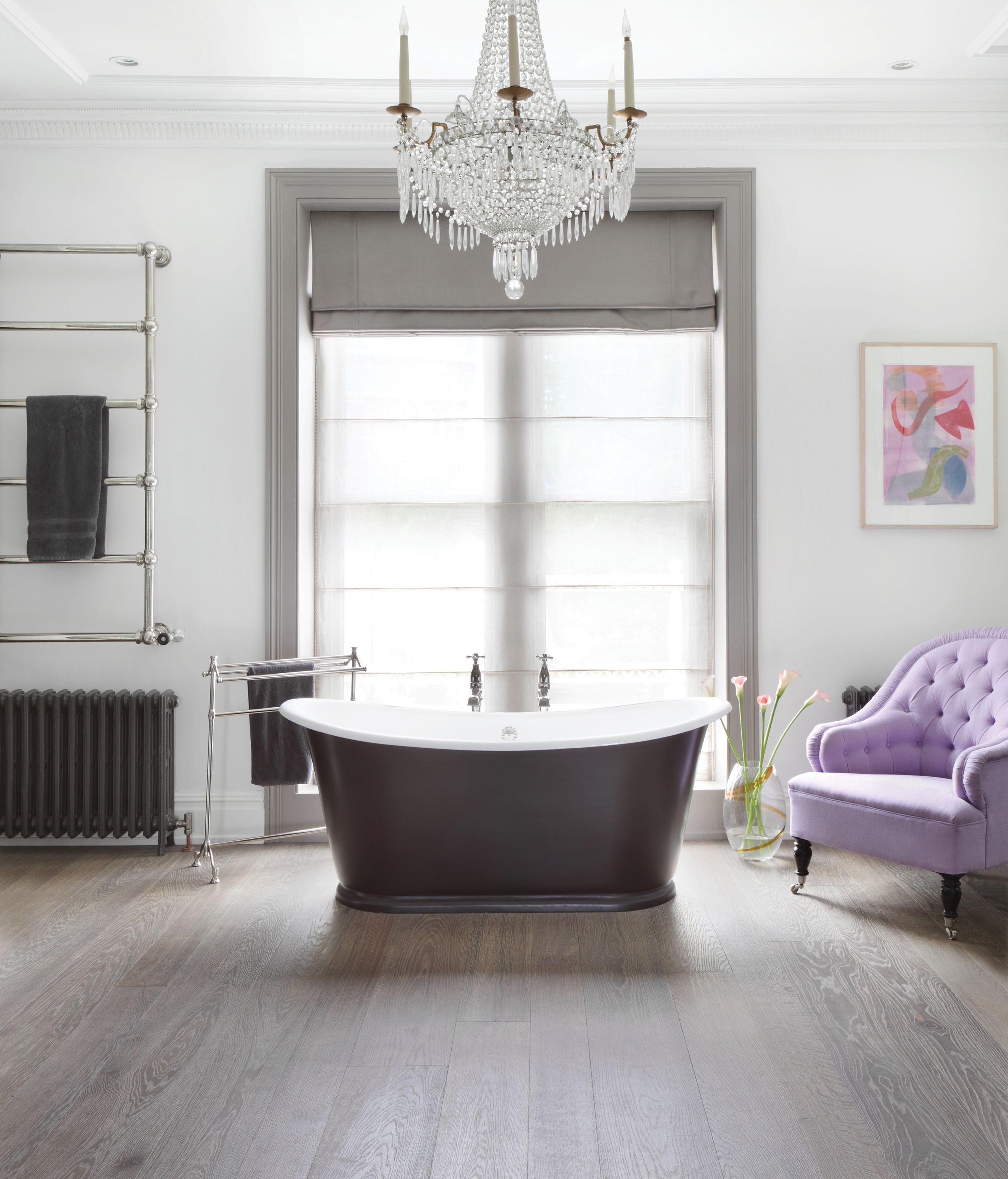 Image may contain: Chandelier, Lamp, Bathing, Indoors, Interior Design, Bathtub, Person, Tub, Chair, Furniture, and Sink