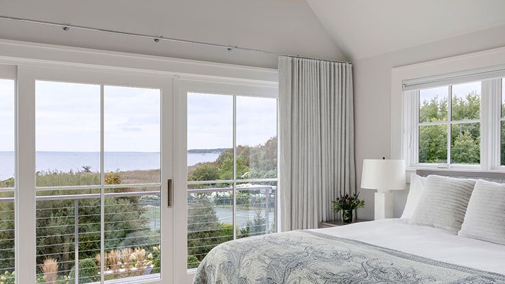 Image may contain: Door, Lamp, Bed, Furniture, Plant, French Window, Window, Architecture, Building, Housing, and House