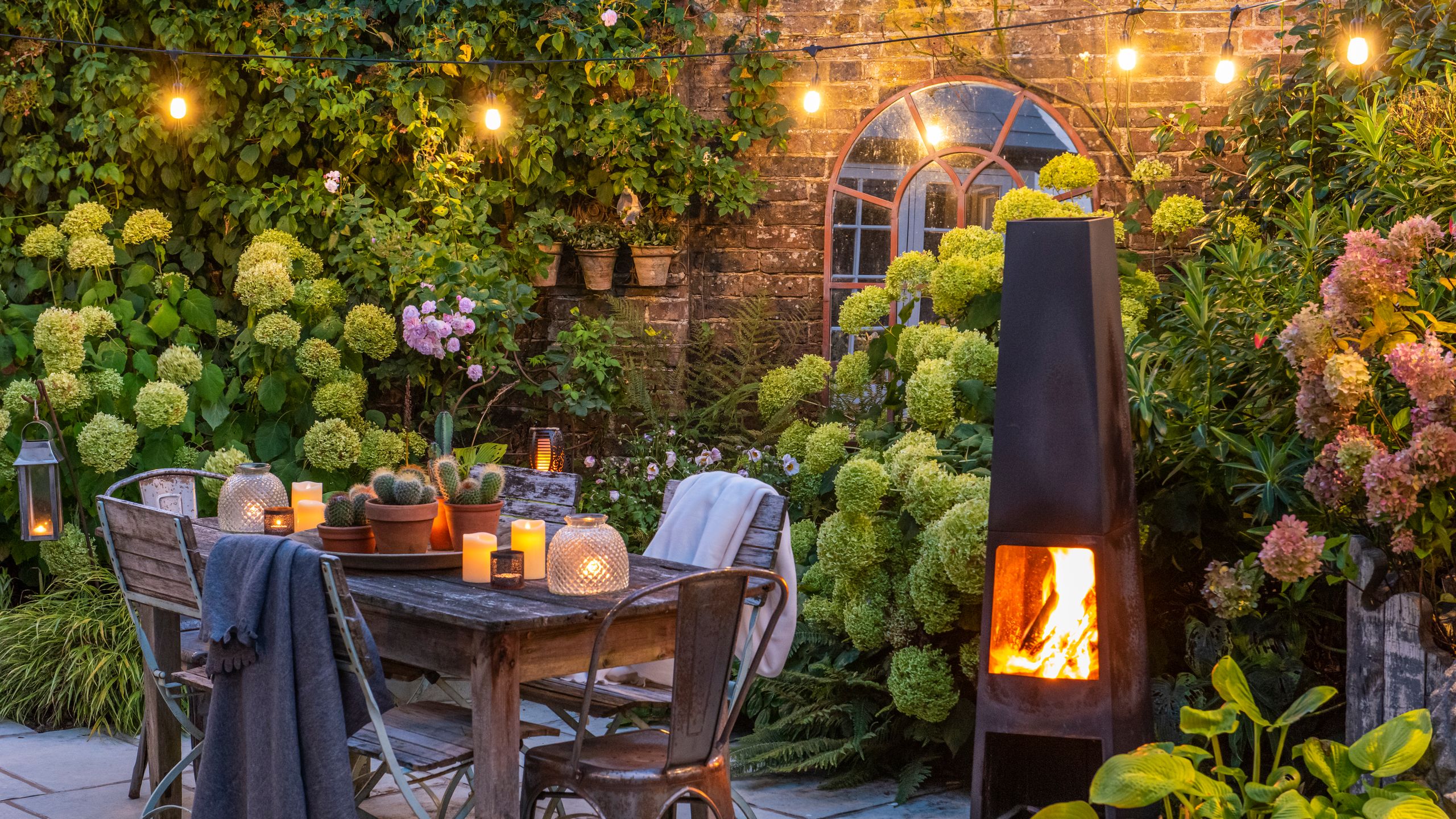 Image may contain: Backyard, Nature, Outdoors, Yard, Plant, Fireplace, Indoors, Chair, Furniture, and Interior Design