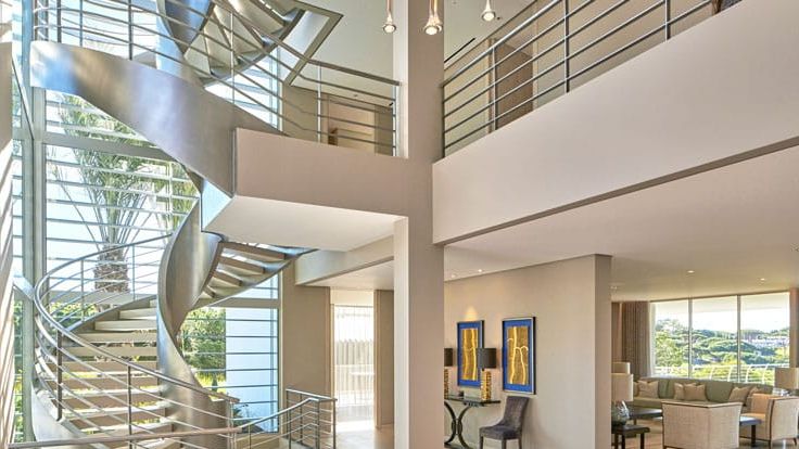 Image may contain: Architecture, Building, House, Housing, Staircase, Chair, Furniture, Desk, Table, Foyer, Indoors, and Art