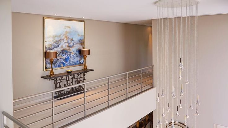 Image may contain: Lamp, Indoors, Interior Design, Chandelier, Art, Painting, Handrail, Architecture, Building, and Foyer