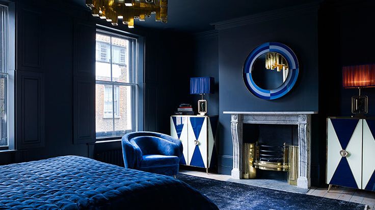 Image may contain: Home Decor, Fireplace, Indoors, Bed, Furniture, Interior Design, Lamp, Rug, Chair, Desk, and Table