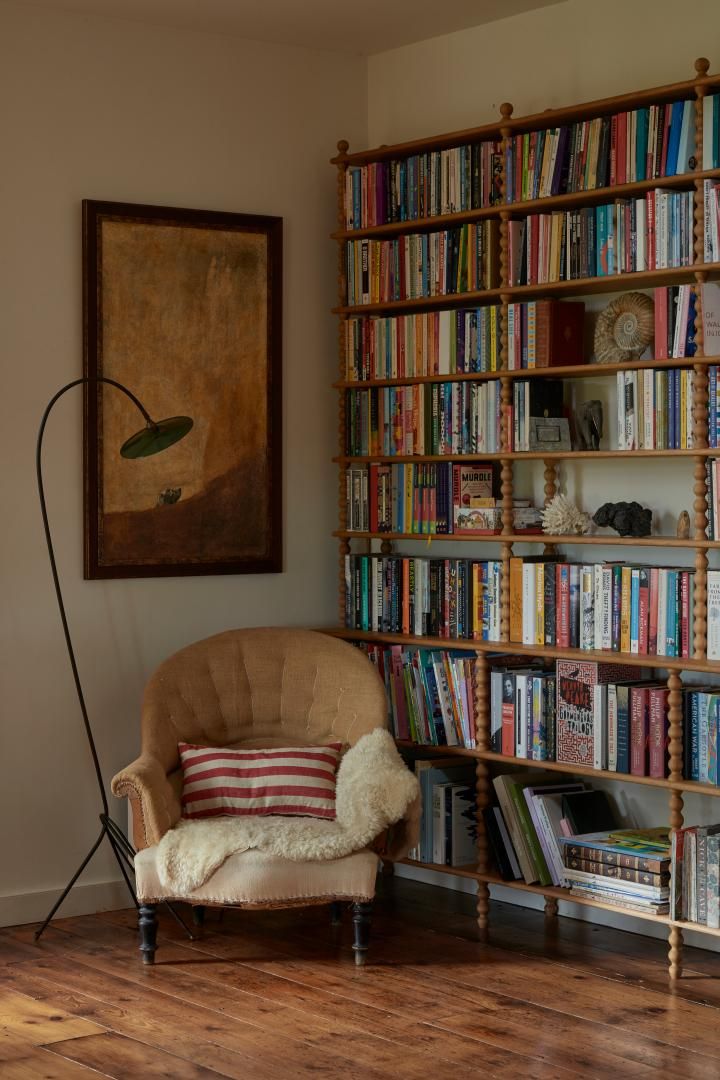 Image may contain: Furniture, Bookcase, Chair, Art, and Painting