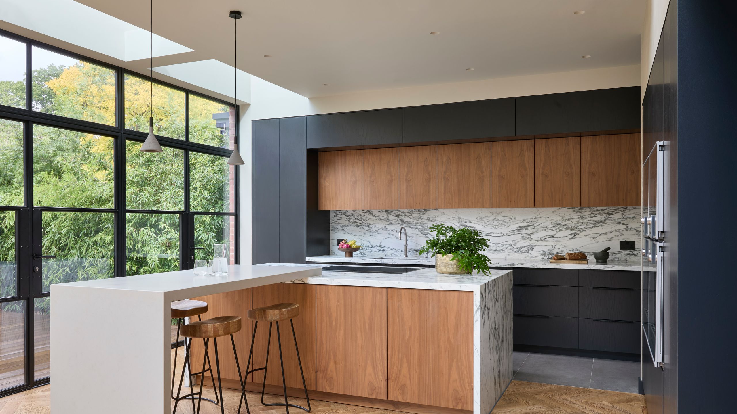 Image may contain: Indoors, Interior Design, Kitchen, Kitchen Island, Floor, Plant, Lamp, and Wood Panels