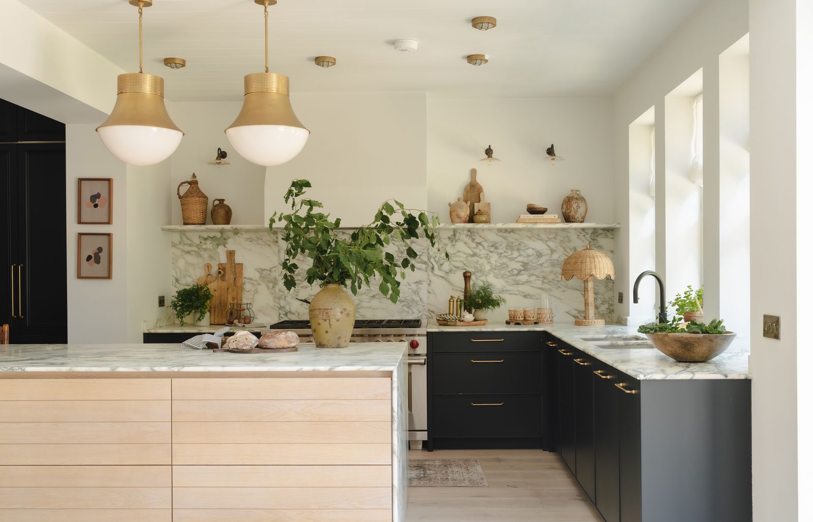 Image may contain Indoors Interior Design Kitchen Kitchen Island Person Plant Sink Sink Faucet Lamp and Art