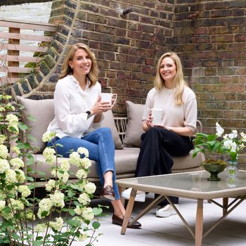 Image may contain: Hayley McQueen, Cup, Clothing, Footwear, Shoe, Adult, Person, Desk, Furniture, Table, and Sitting