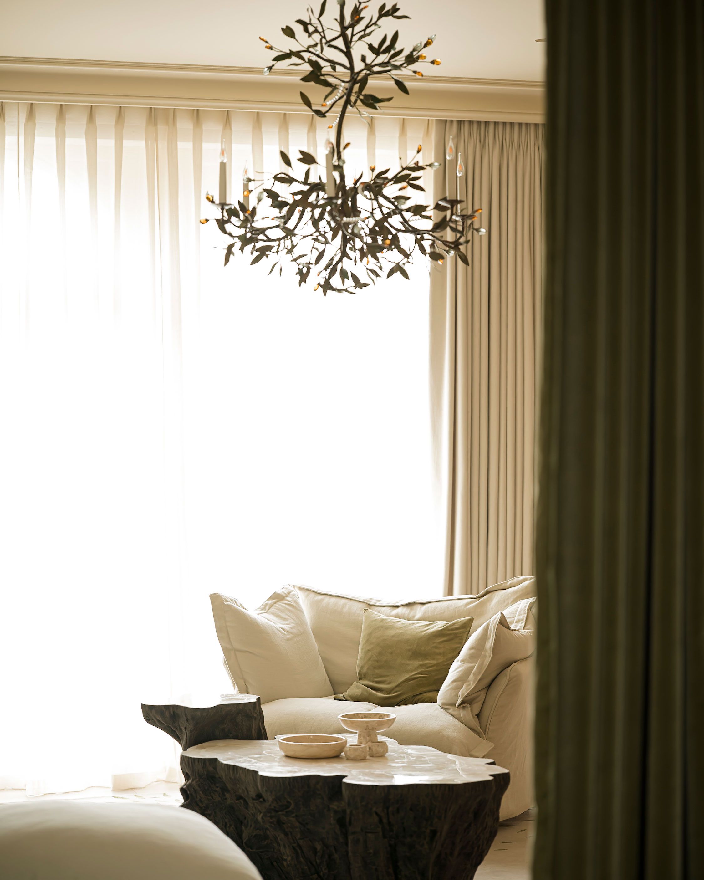 Image may contain: Lamp, Home Decor, Chandelier, Couch, Furniture, Cushion, Table, Indoors, Interior Design, and Pillow