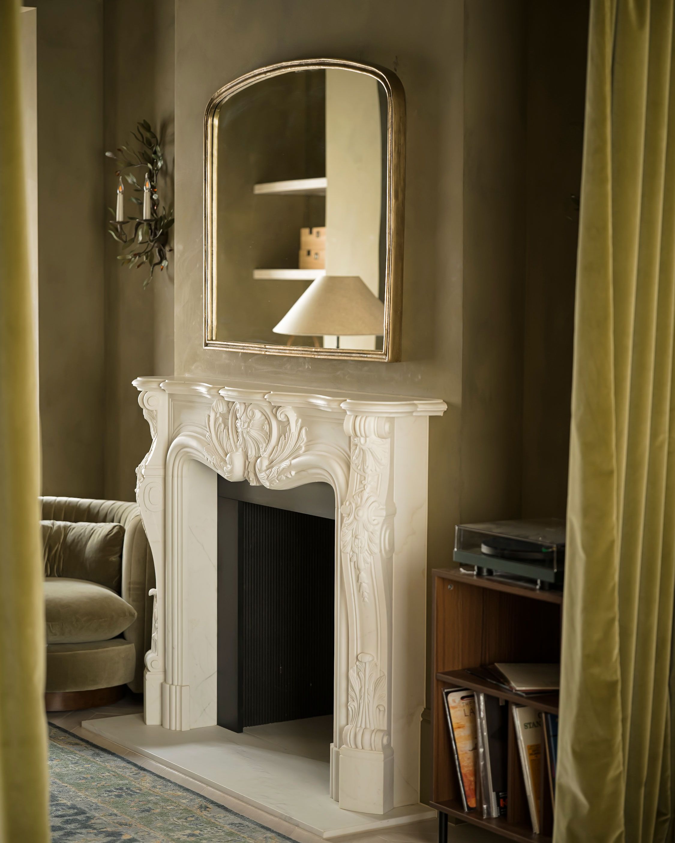 Image may contain: Fireplace, Indoors, Lamp, Hearth, Couch, and Furniture