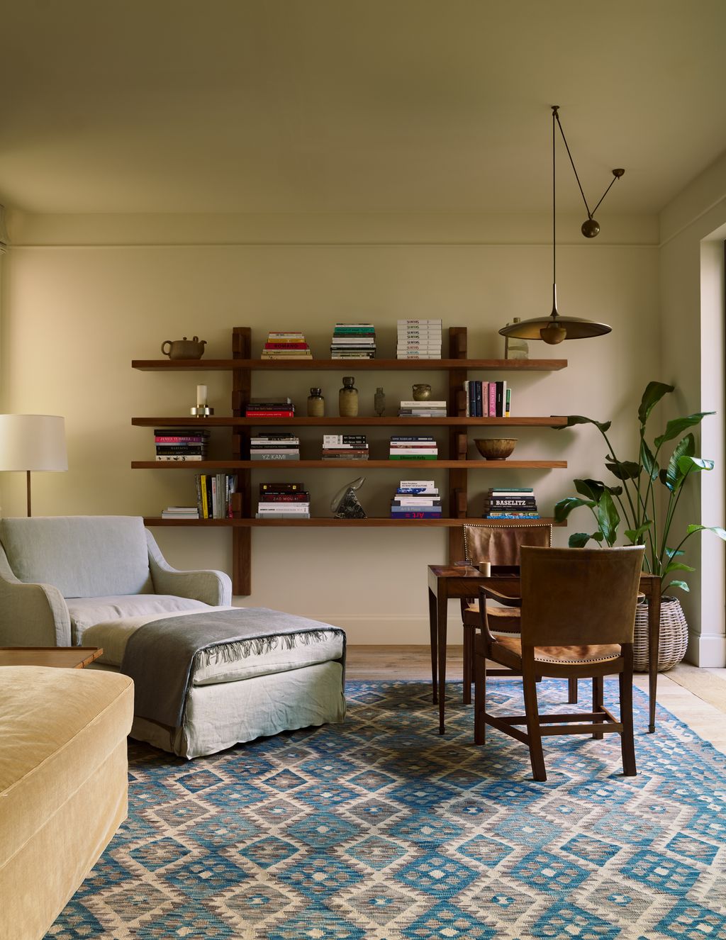 Image may contain Home Decor Chair Furniture Lamp Architecture Building Indoors Living Room Room Plant and Rug