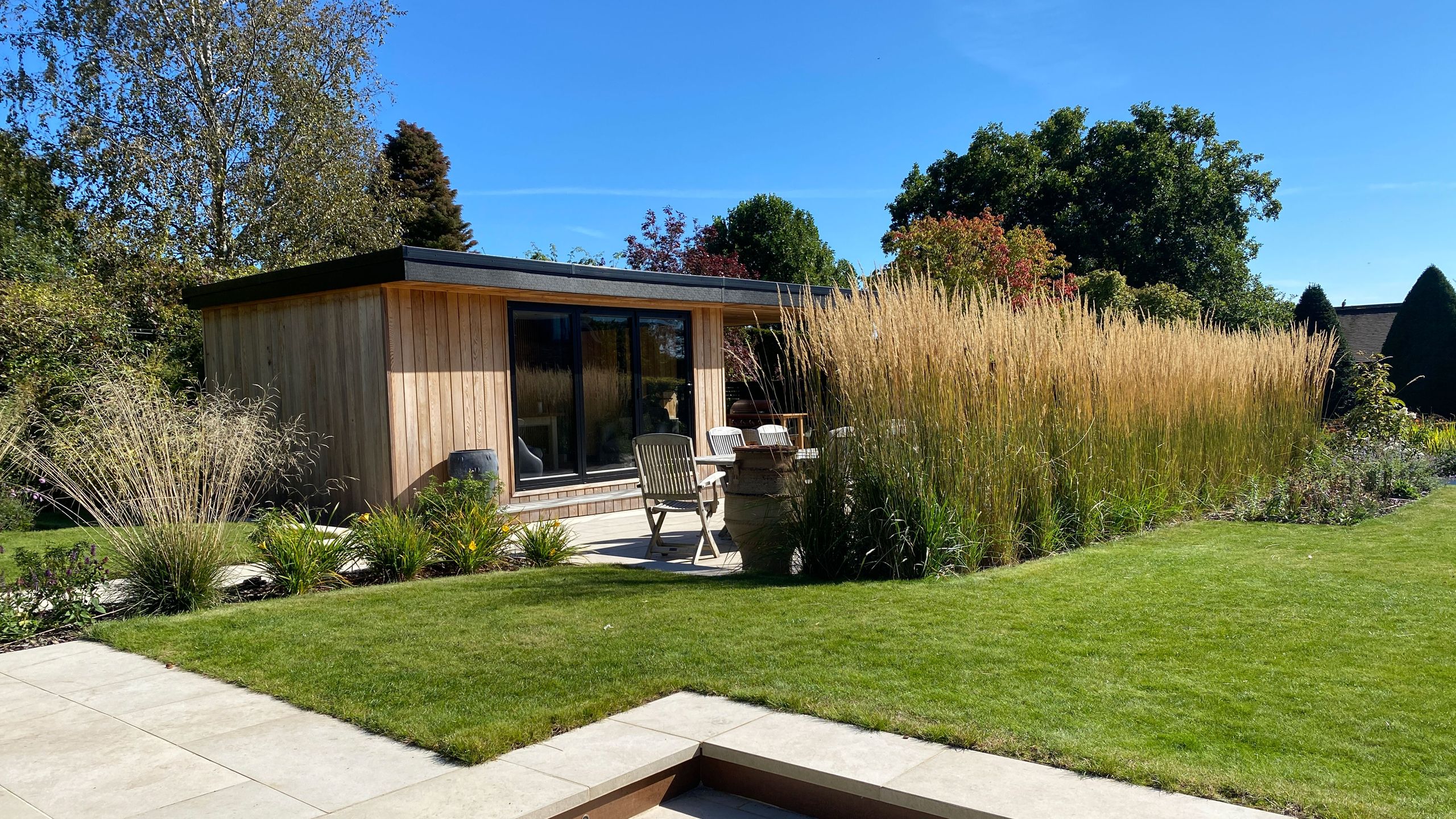 Image may contain: Grass, Plant, Indoors, Interior Design, Backyard, Nature, Outdoors, Yard, Chair, Furniture, and Lawn