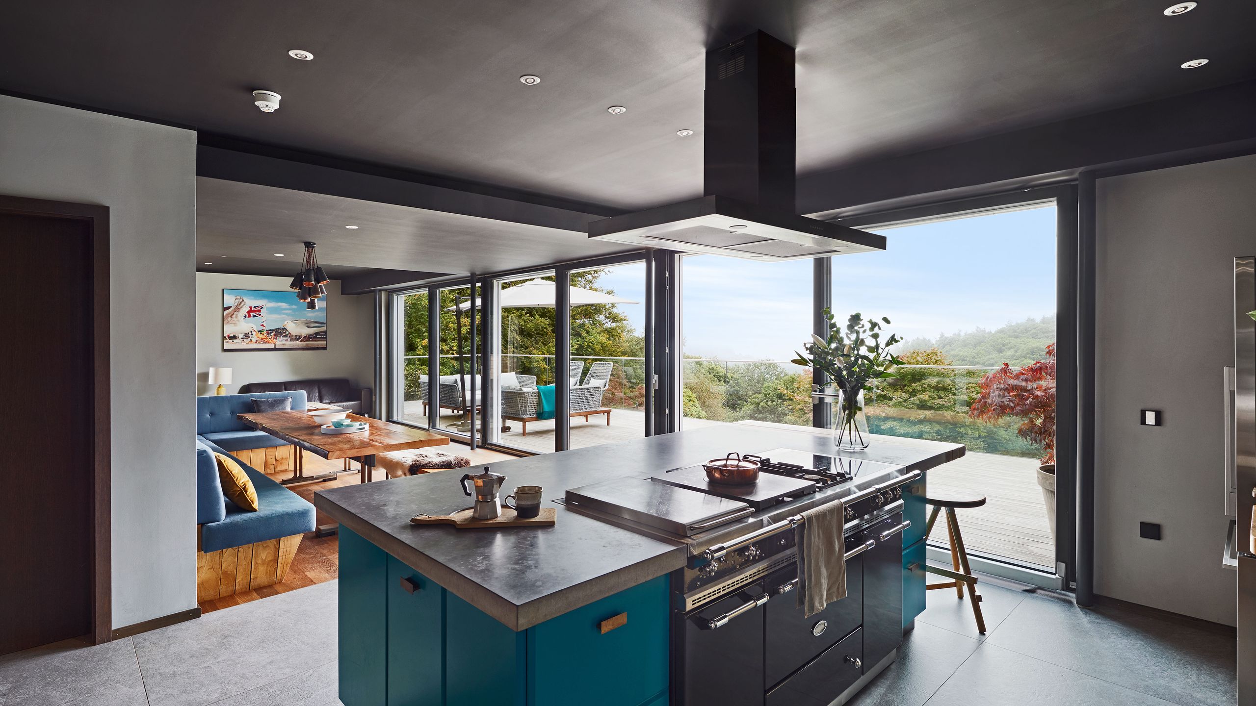 Image may contain: Indoors, Interior Design, Kitchen, Kitchen Island, Cup, Plant, Appliance, Ceiling Fan, and Device