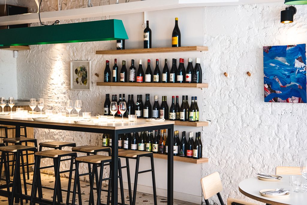 Image may contain Lamp Art Painting Chair Furniture Cup Desk Table Alcohol Beverage Plate and Bottle