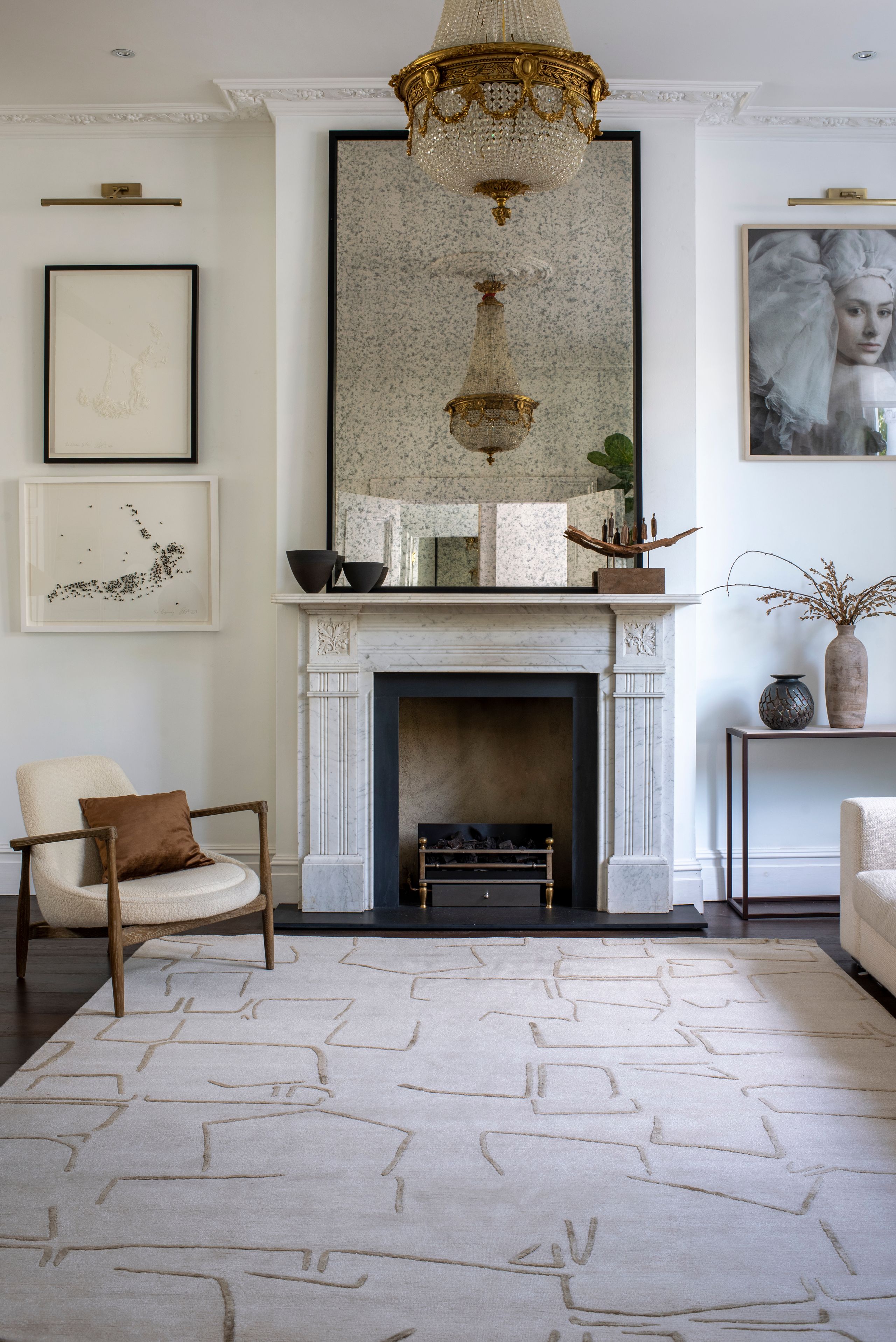 Image may contain: Home Decor, Floor, Fireplace, Indoors, Chair, Furniture, Flooring, Lamp, Rug, Plant, Art, and Painting