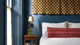 Image may contain Indoors Interior Design Home Decor Cushion Bed Furniture Wood Panels Lamp Pillow and Bedroom