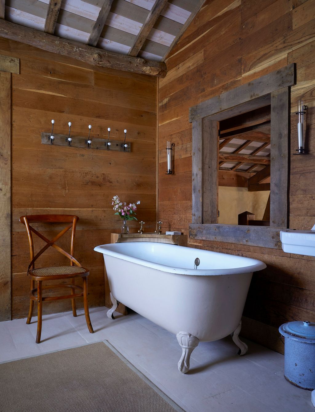 Image may contain Indoors Interior Design Chair Furniture Bathing Bathtub Person Tub Wood Home Decor Rug and Sink